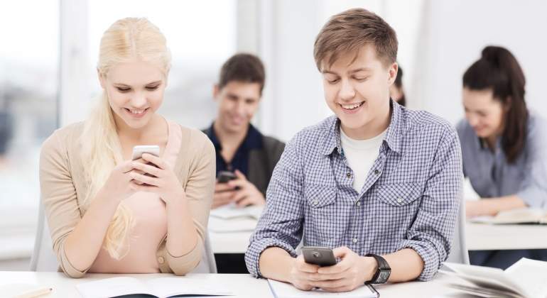 Estudiantes con el mvil en clase