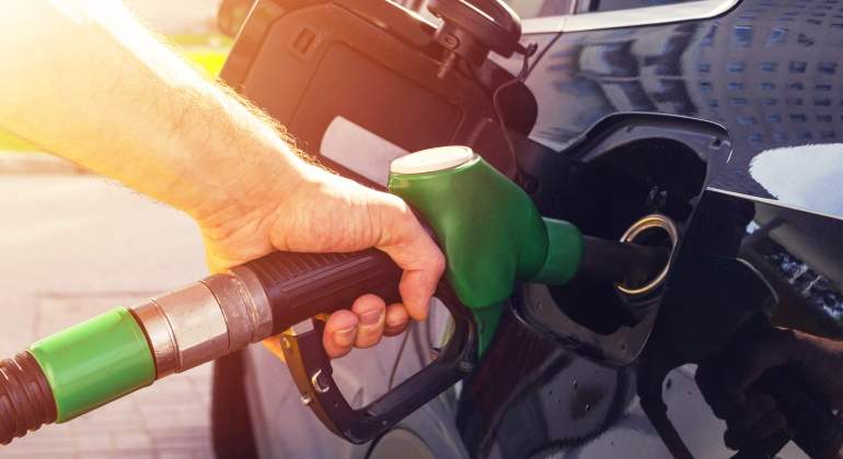 Una persona reposta lo que parece un combustible verde o ecocombustible en su vehculo
