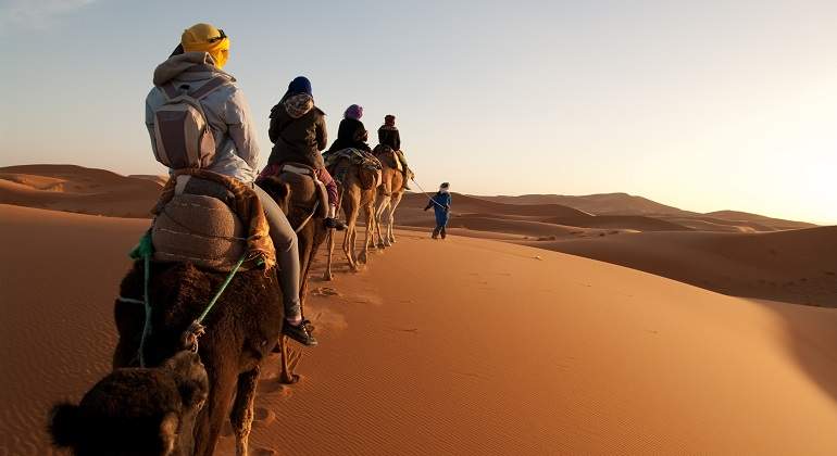 Un-grupo-de-personas-en-camello-paseando-por-el-Sahara-iStock.jpg