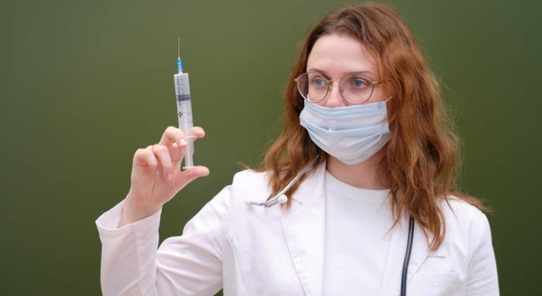 Una doctora con una jeringuilla en una clase