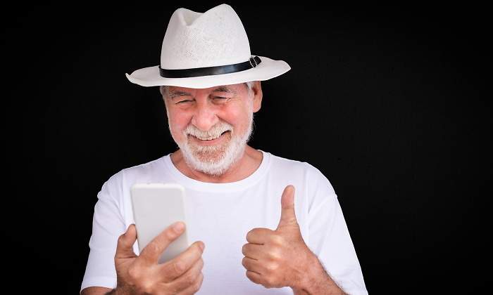 jubilado-feliz-movil-fondo-negro-dreamstime.jpg