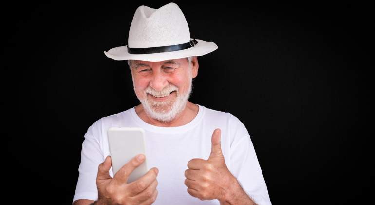 jubilado-feliz-movil-fondo-negro-dreamstime.jpg