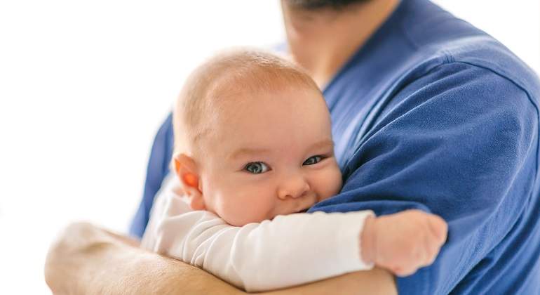 Un-bebe-en-brazos-de-un-hombre-con-camiseta-azul-iStock.jpg