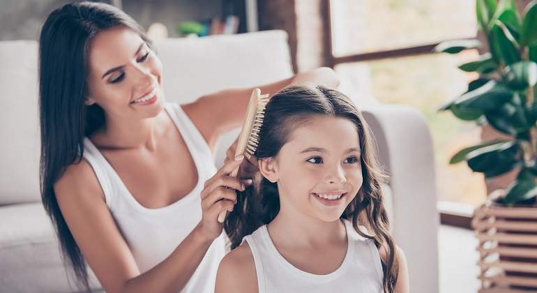 Una-mujer-cepillandole-en-cabello-a-una-nina-iStock.jpg