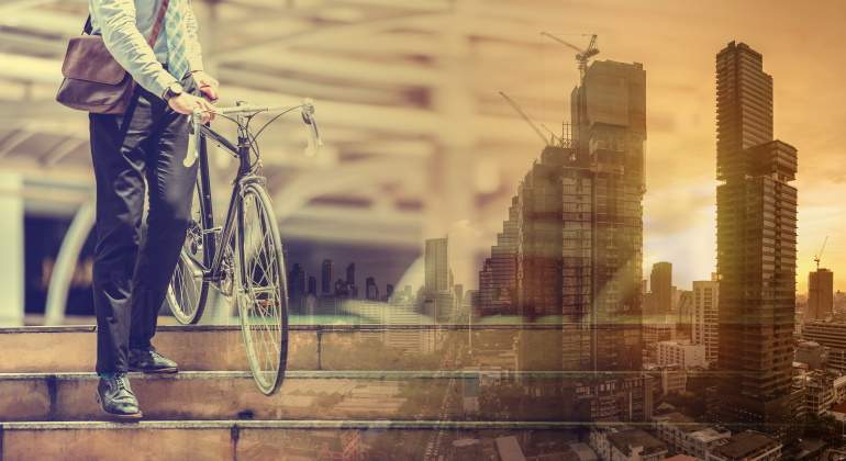 Un hombre se dispone a montar en bicicleta en la ciudad