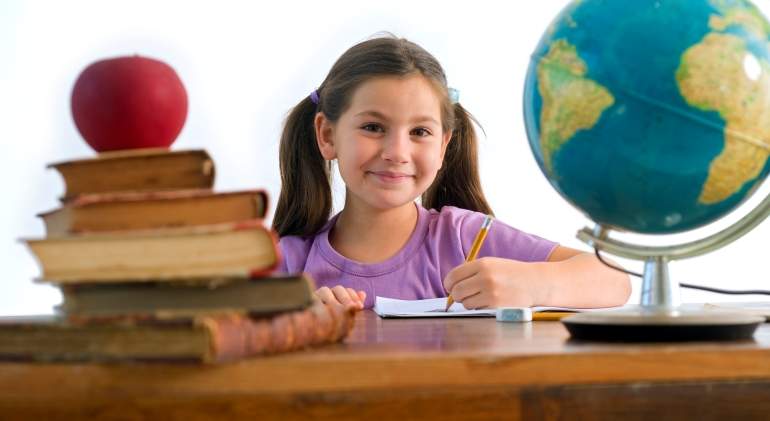 Una nia hace sus tareas con un globo terrqueo