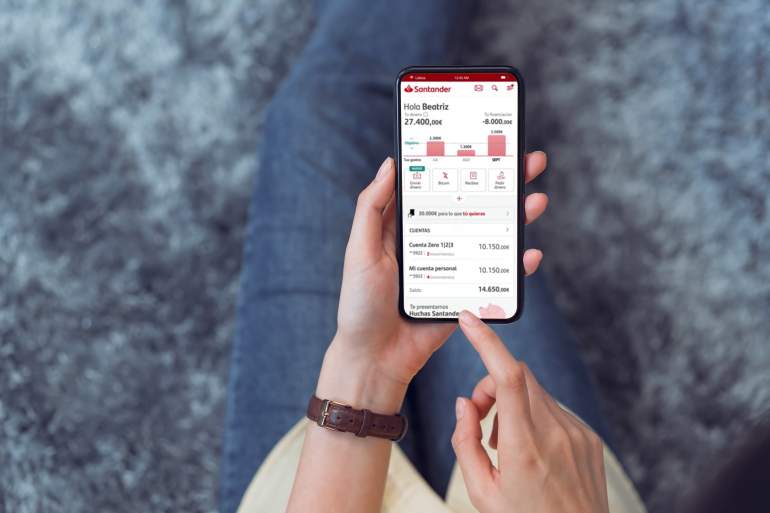 Una persona sostiene un mvil donde se ejecuta la app de Banco Santander